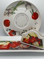 Round serving bowl, rectangular platter and napkin holder showing vegetable motifs