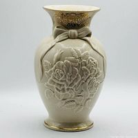 Front view of ivory fine china vase showing raised rose design, bow, gold trim