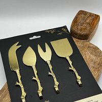 Brass cheese cutter set in original packaging with mango wood board partially visible