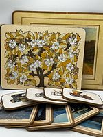 Group of placemats and coasters showing floral placemat, stacked scenic coasters and automobile coasters