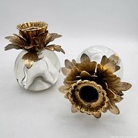 Pair of glass globe candlesticks with brass petal tops, one upright, one on side showing profile.