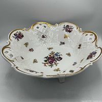 Top view showing scalloped rim, floral sprays, gold trim, lattice cutouts