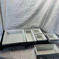 Front angled view of assembled serving set showing raised tray and porcelain dishes