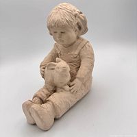 Front angled view of full sculpture showing child and rabbit