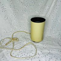 Full view of cylindrical can light lamp with cord visible