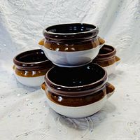 Stacked view of four brown drip glaze stoneware soup bowls