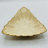 Top view of ivory Lenox triangular shell bowl showing gold trim and sculpted detail