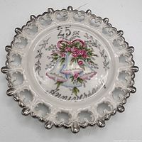 Front view showing pierced rim, silver trim and anniversary motif