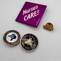 Front view of all four pins showing designs and text