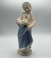 Front view of porcelain figurine showing girl holding duck