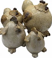 Front grouping of all four pottery chickens showing size variation and detailing