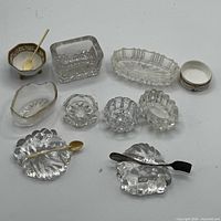 Group shot of all salt cellars, utensil rests and spoons arranged on surface