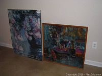 Two framed prints leaned against a wall. One is a Metropolitan Museum of Art 1986 Impressionist Eye poster, the other is a colorful Paris canal scene with boats and figures.
