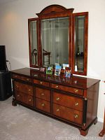 Full frontal view of dresser and mirror with decorative photos on top