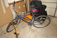 Photo of metallic blue GT Slipstream 16-inch bike, showing overall shape, two helmets on the seat, and yellow manual floor pump nearby.