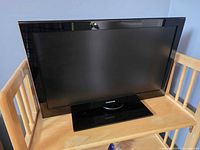 Front view of Toshiba LED TV on wooden stand