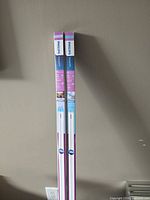 Two Philips InstantFit LED T8 tubes in packaging standing upright