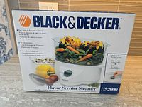 Front of sealed box showing Black & Decker Flavor Scenter Steamer HS2000 image and branding