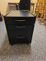 Front view showing drawers, handles, casters