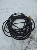 Coiled black rubber garden hose on snow