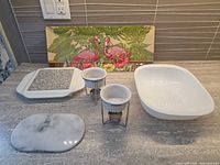 All items overview: casserole dish, two butter warmers, granite hot plate, marble hot plate, flamingo tray
