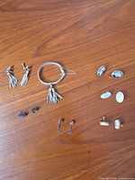 All items grouped on tabletop: bracelet and six earring pairs