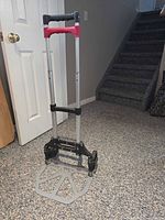 Hand truck extended showing handle, frame, wheels and base plate