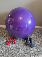 Overview of purple exercise ball with dumbbells