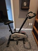 side view showing full bike profile, seat, pedals, flywheel cover