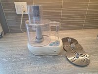 Food processor with three discs on countertop