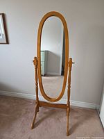 Front view of full length oval mirror on stand