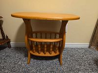 Front view of oak table showing book rack shelf and spindle supports