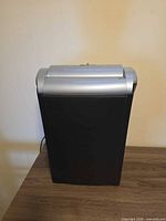 Front view of black shredder with silver top