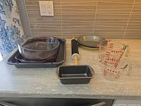 Group shot: round glass dish, broiler pan, rolling pin, loaf pan, measuring cups