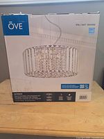 Front of sealed OVE Patience chandelier box showing product image and branding