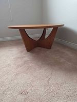 Side view showing V-shaped pedestal base and wood finish