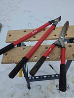 Bypass loppers and hedge shears on workbench in snow