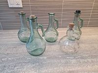 Five small glass decanters on countertop