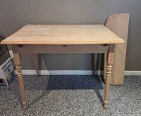 Full view of table front with separate leaf panel leaning against wall