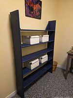 Full view of blue painted shelf unit against wall