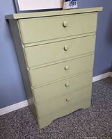 Front view of light green 5-drawer dresser