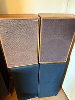 All four speakers, two brown-grille bookshelf units stacked on two black-cloth B&W speakers