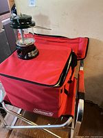 Lantern resting on cooler bag atop folding chair