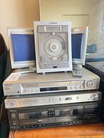 Front view of stacked Fisher CD player, Sony DVD player, Samsung DVD player, Technics cassette deck