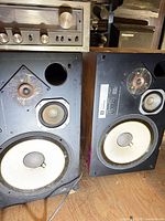 Front view of both JBL L100 Century speakers showing drivers and cabinet