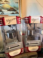Two red and white Nostalgia Electrics kettle popcorn machines side by side