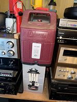 Maroon Coleman propane lantern case on top of boxed lantern