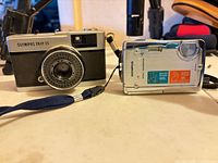 Both Olympus cameras side by side showing fronts and straps