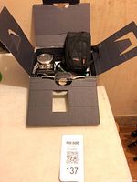 Cardboard box opened showing camera and carry case