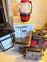 Group view of radios, lanterns, AR speaker, XM kit and boxed propane lantern